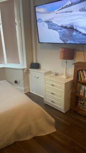 Schlafzimmer mit einem Bett und einem Flachbild-TV in der Unterkunft Bexhill Stunning 2 bedroom Sea Front Bungalow in Bexhill