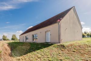 a house on top of a grassy hill at Logis de beauce in Boisgasson