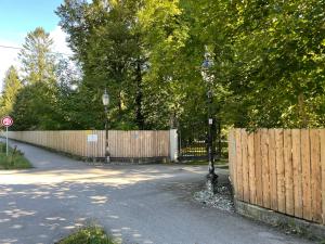 a fence and a street light next to a road at Villa Zollhaus Bed & Breakfast in Türkheim