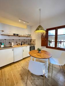 a kitchen with a wooden table and white chairs at Los Nidos Apartments, Frigiliana in Frigiliana