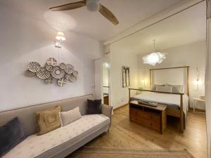 een slaapkamer met een bed, een bank en een spiegel bij Los Nidos Apartments, Frigiliana in Frigiliana