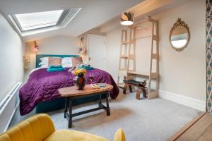 a bedroom with a purple bed and a table at Albert Road Apartments Flat 3 in Colne
