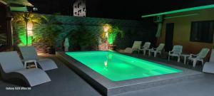 a swimming pool with white chairs at Karon Homes in Karon Beach