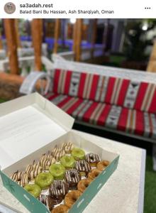 een doos donuts bovenop een tafel bij أستراحة السعادة in Jalan Bani Buhassan