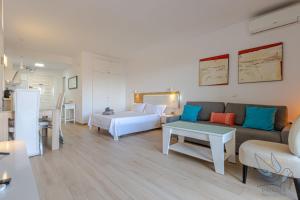 een woonkamer met een bank en een bed bij Benal beach suite, parque acuático y vistas al mar in Benalmádena