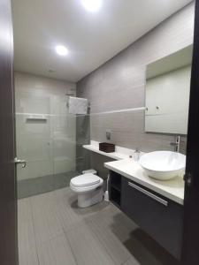 a bathroom with a toilet and a sink and a shower at Modernidad en un Oasis Verde in Santa Ana