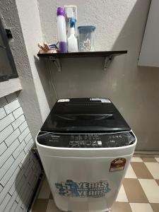 Un inodoro en un baño con un estante en la parte superior. en Family apartment in Tawau Town, en Tawau