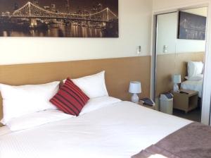 a hotel room with a bed and a lamp at PA Apartments in Brisbane