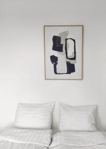 une chambre avec un lit et un tableau au mur dans l'établissement Kotimaailma Apartments Loimu VIII, à Oulu