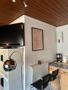 a kitchen with a table and two chairs and a television at Sauerlandapartment Vivien in Plettenberg