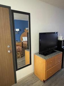 a hotel room with a tv and a mirror at Express extended in Junction City