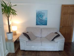 sala de estar con sofá y maceta en Ocean City Apartment-with parking en Plymouth