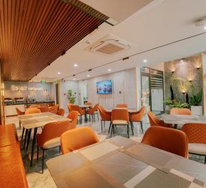 a restaurant with tables and chairs in a room at Bel-air Hotel in Quy Nhon