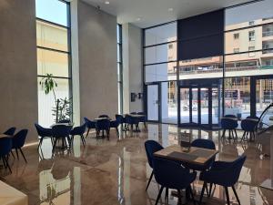 um restaurante com mesas e cadeiras num edifício em Beautiful Studio in Gibraltar - E1 Suites & Spa em Gibraltar