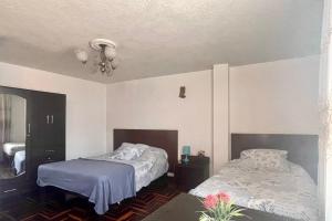 a bedroom with two beds and a chandelier at Samadri in Arequipa