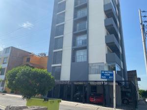 a tall building with a blue sign in front of it at Samadri in Arequipa