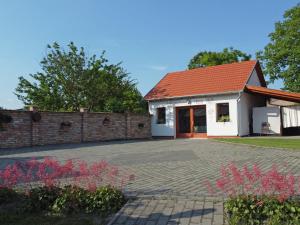 uma casa com uma entrada de tijolos e um telhado vermelho em Füzesi Papa Vendégháza em Harta