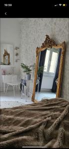 1 dormitorio con espejo, mesa y silla en Chez Tess, en Metz