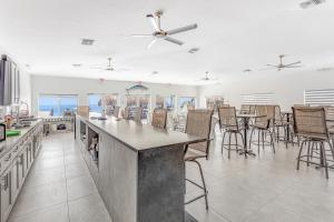 a kitchen with a bar with chairs and tables at Ocean Isles #119 in Marathon