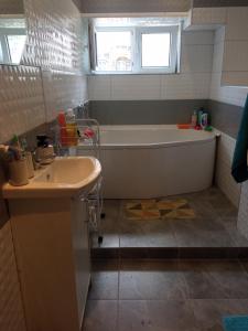 ein Badezimmer mit einer Badewanne und einem Waschbecken in der Unterkunft Rafaelo Władycze 17/4 in Przemyśl