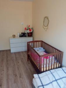 a bedroom with a crib and a dresser with flowers at Rafaelo Władycze 17/4 in Przemyśl