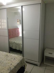 een slaapkamer met een kast met een spiegel en een bed bij Pousada Boulevard in Florianópolis