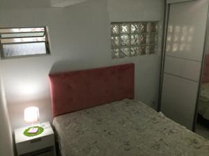 een slaapkamer met een bed, een lamp en een raam bij Pousada Boulevard in Florianópolis