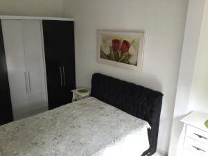 een slaapkamer met een bed en een schilderij aan de muur bij Pousada Boulevard in Florianópolis