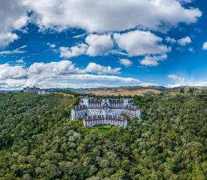 una vista aérea de una mansión en una colina con árboles en Hotel Home Green Home, en Campos do Jordão