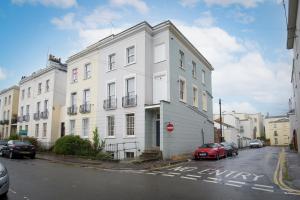 a white building with a red car parked in front of it at K Suites - Kauto Star Suite in Cheltenham