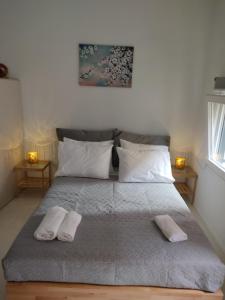 un dormitorio con una cama con dos almohadas. en cortile antico, en Corfú