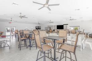 Green Pineapple في ماراثون: غرفة طعام مع طاولات وكراسي ومروحة سقف