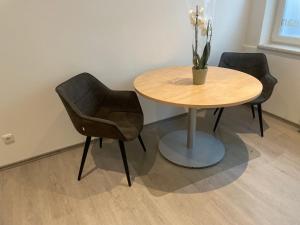 einem Tisch mit zwei Stühlen und einem Tisch mit einer Pflanze darauf in der Unterkunft Deluxe Living Krefeld Zentrum, Nähe Düsseldorf in Krefeld