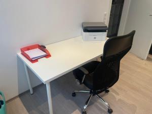 einen weißen Schreibtisch mit einem schwarzen Stuhl und einem Drucker in der Unterkunft Deluxe Living Krefeld Zentrum, Nähe Düsseldorf in Krefeld