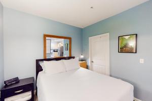 une chambre avec un lit blanc et un miroir dans l'établissement San Diego's Diamond: Snowbird-friendly studio near ocean with pool, hot tub, gym, balcony - dogs OK, à San Diego 10 autres photos