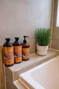 three bottles of soap sitting on a shelf next to a sink at Garden of Eden 1 Bedroom Flat in Fishponds in Bristol