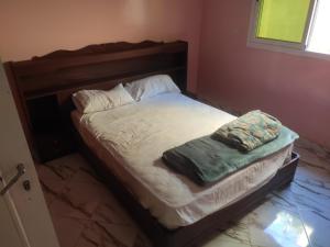 a small bed in a bedroom with a pillow on it at Family House in Kenitra