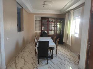 uma sala de jantar com mesa e cadeiras em Family House em Kenitra