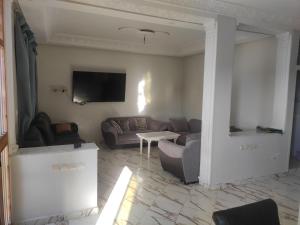 uma sala de estar com um sofá e uma televisão em Family House em Kenitra