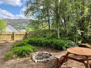 a backyard with a picnic table and a fire pit at Homestead House, Fort Augustus in Fort Augustus