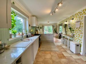 a large kitchen with white cabinets and a tile floor at Homestead House, Fort Augustus in Fort Augustus