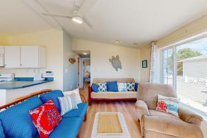 a living room with a blue couch and two chairs at Bay-View Beauty in Assateague Point in Berlin