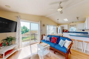 a living room with a blue couch and a kitchen at Bay-View Beauty in Assateague Point in Berlin