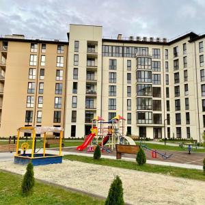 a playground in front of a large building at Апарт-СЕРВiC жк Сонячний квартал in Solochin