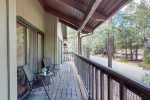 a balcony with two chairs and a table on it at Sway of the Pines, Unit#32A in Indian Pine