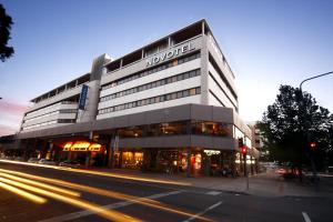 a building on the corner of a city street at Novotel Canberra in Canberra