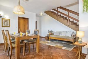 a dining room with a table and a couch at Green Valley by Homie in Porto Moniz