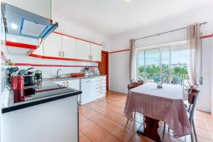 a kitchen with white cabinets and a table with a table cloth at Peaceful 1 BDR Apartment W/ Balcony by LovelyStay in Almancil