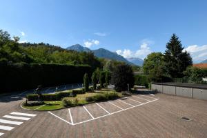 ein Parkplatz mit Bäumen und Bergen im Hintergrund in der Unterkunft Hotel Internazionale in Domodossola