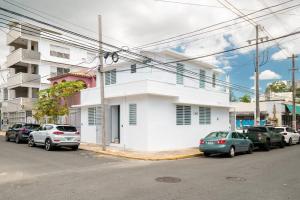 un edificio blanco con coches estacionados frente a él en 1 Santurce 1 Bedroom 1Bathroom Apt en San Juan